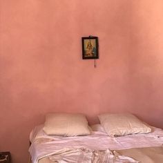 a bedroom with pink walls and white linens