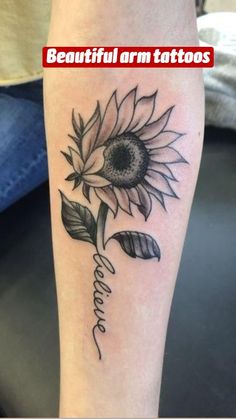 a sunflower tattoo on the arm with words written below it and an arrow in the middle