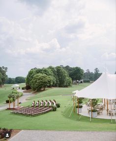 a large white tent set up for an outdoor wedding ceremony with chairs and tables in the grass