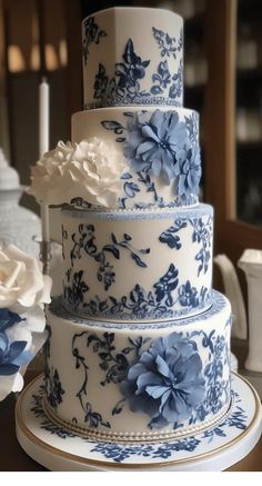 a blue and white wedding cake with flowers on it