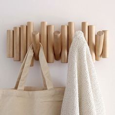 wooden pegs are hanging on the wall next to a bag