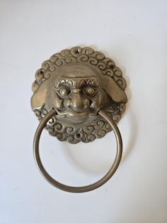 a metal ring with a lion head on it's face hanging from a wall