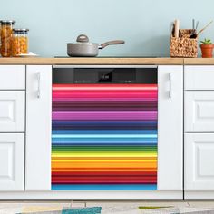 a multicolored dishwasher sitting on top of a kitchen counter next to a pot and pan