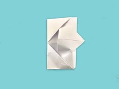 an origami sculpture is shown on a blue background, with the paper folded over it