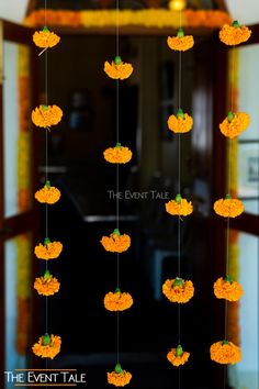 orange flowers hanging from strings in front of a doorway with the words, the event tab