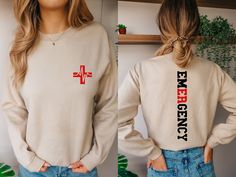 a woman wearing a sweatshirt with the words emergency printed on it and an image of a cross