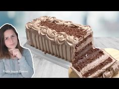 a woman standing in front of a cake with chocolate frosting on it and a piece missing