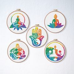 four embroidered hoops with colorful images of people sitting on lotuses in different colors