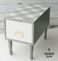 a white and gray checkered drawer on a wooden table with the word organized cuff