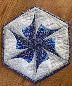 a blue and white star quilted on top of a wooden table