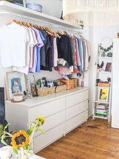 an organized closet with clothes and sunflowers