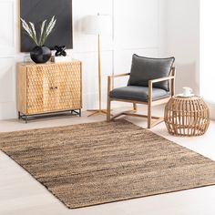 a living room with a rug, chair and sideboard