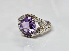 Vintage Sterling Silver Lab Created Amethyst Floral Design Ring    In very good pre-owned condition with light surface wear, light scratches, minor dings and imperfections and light patina throughout. Light gold plating residue. Stamp  925 C^A Size 7.25 Width 14mm / 0.55 in Weight 6.8 grams Photos show the item that is being sold. Please check photos for details before purchase because photos are part of the description. This item has NOT been polished, because most customers prefer the patina/vintage look, or prefer to polish it themselves. Items are gently washed with warm water and soap. Photos are close up to show details and thus the item may appear larger/smaller than it is. Refer to the description and photos of the item with ruler or other measuring tools for size reference.  Pleas Silver Lab, Ring Size 7, Solitaire Ring, Gold Plating, Vintage Sterling Silver, Vintage Looks, Patina, Close Up, Jewelry Rings