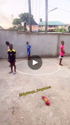 several children are playing soccer in an outdoor area with concrete walls and cement flooring