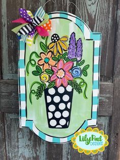 a painted sign with flowers in a vase