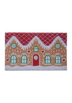 a gingerbread house door mat with hearts on the front and windows in red, green, yellow and white