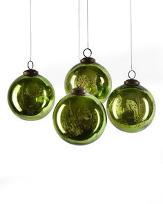 four green glass ornaments hanging from strings