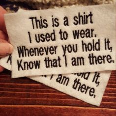 someone is holding two pieces of paper with words on it that read, this is a shirt i used to wear whenever you hold it, and know that i am there