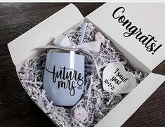 a cup and spoon in a gift box with congratulations written on the side next to it