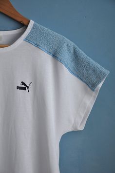 Vintage white and baby blue PUMA sports top, from the 1980s Summer 80s PUMA top with dolman short sleeves and long straight shape. The top features light blue terry cloth pieces on the shoulders, the rest is white! Has the brand's logo on the front Material - cotton and polyester, fabric is thick, not lightweight! Size - L Measurements (taken while top is lying flat, double armpit to armpit): Shoulders (undefined), measured from one sleeve's end to the other - 28.5 inches / 72.4 cm Armpit to Arm 90s Sports T-shirt For Summer, White Sporty Top For Summer, Sporty White Top For Summer, Retro Sports T-shirt For Summer, 90s Summer Sports T-shirt, Sporty White T-shirt For Summer, 1980s Summer, Summer 80s, Cloth Pieces