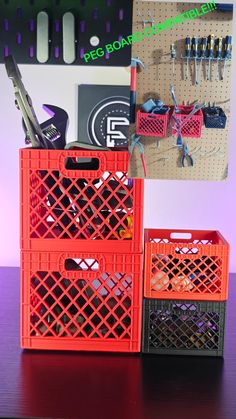 two orange baskets sitting on top of a wooden table next to pegboards and scissors