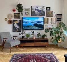 a living room filled with furniture and lots of pictures on the wall above it's tv