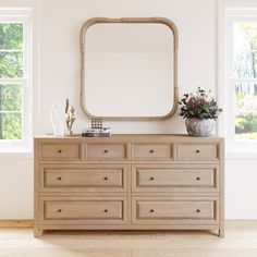 a dresser with a mirror and vase on top