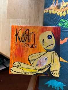 a painting of a yellow stuffed animal with the words korn issues on it