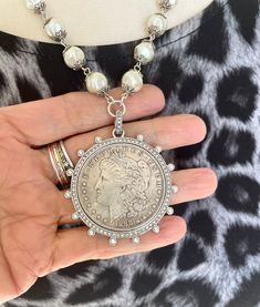 "This is a beautiful reproduction of an antique silver dollar.  It is set in a bezel accented with pearls and cubic zirconia crystal gems.  The Czech pearl chain shimmers in the light to enhance the bezel settings.  It is finished with silver chain heavily plated with sterling silver. This necklace is a maximum of 20\" long, but can be adjusted to be a bit shorter by hooking the lobster clasp along the chain links." Silver Coin Jewelry, Necklace With Pearls, Silver Coin Necklace, Coin Bracelet, Chain Links, Coin Jewelry, Silver Coin, Silver Dollar, Vintage Jewels