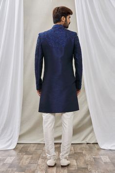 Blue sherwani with floral embroidery and mandarin collar. Paired with pant.
Component: 2
Pattern: Embroidered
Type Of Work: Floral
Neckline: Mandarin
Sleeve Type: Full Sleeves
Fabric: Art Banarasi Silk, Dupion Art Silk
Color: Blue
Other Details: 
Floral embroidery
Front buttons
Note: Pocket square worn by the model is not for sale
Occasion: Sangeet - Aza Fashions Fitted Royal Blue Traditional Wear For Reception, Elegant Blue Salwar Kameez With Naqshi, Blue Formal Unstitched Suit With Traditional Drape, Blue Semi-stitched Sherwani For Diwali, Blue Bollywood Sherwani For Diwali, Blue Semi-stitched Traditional Wear For Formal Occasions, Blue Bollywood Nehru Jacket With Intricate Embroidery, Traditional Blue Sherwani With Resham Embroidery, Blue Wedding Salwar Kameez With Naqshi Detailing