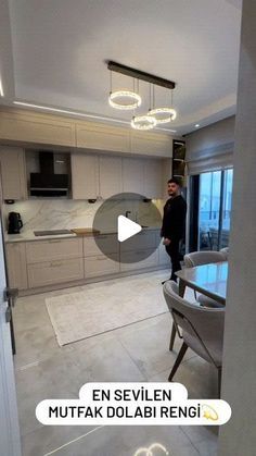 a man standing in a kitchen next to a dining room table with chairs and an oven