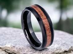 a black ceramic ring with an exotic wood inlay and beveled into it