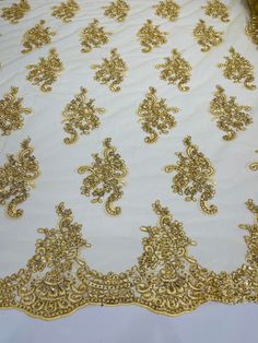 gold embroidered lace on white fabric