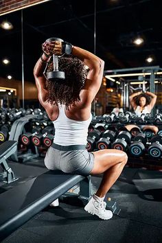 a woman squatting on a bench in a gym