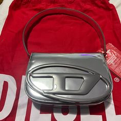 Structured And Compact, This Iconic Women's Bag Has A Handle That Fits Over The Shoulder And An Optional Strap For Crossbody Wear. The Electroplated Oval D Plaque On The Flapsignature Element Of The Stylematches The Glossy, Mirrored-Leather Construction. The Red Variant Of This Item Is A Limited Edition. Minor Scratch At Back Of Bag (Please See - Can’t Even Notice!) Comes With Cross Strap Too. Never Opened. Sealed. Luxury Shoulder Bag With Silver-tone Hardware Handheld, Luxury Handheld Shoulder Bag With Silver-tone Hardware, Shopping Shoulder Bag With Top Handle And Logo Hardware, Top Handle Shoulder Bag For Shopping With Logo Hardware, Designer Handheld Shoulder Bag, Designer Handheld Bag With Branded Hardware, Designer Tan Shoulder Bag, Modern Shoulder Bag With Logo Hardware For Shopping, Modern Bags With Logo Hardware For Shopping