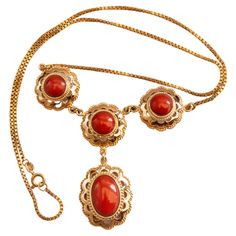 A vintage 14 karat yellow gold necklace with a gold ornament set with genuine red coral cabochons. The ornament consists of three connected gold flower-shaped links with cabochon-cut round red coral, of which one is linked with an oval red coral set in a gold setting. The necklace could be combined with classy as well modern outfits and it is suitable for a woman in any age. The item is in very good vintage condition and it will be delivered in a jewelry gift box. The necklace was tested for the Antique Yellow Gold Necklace With Cabochon, Traditional Cabochon Necklace For Formal Occasions, Traditional Formal Cabochon Necklace, Elegant Red Coral Necklace For Formal Occasions, Elegant Red Coral Necklace For Formal Events, Vintage Yellow Gold Cabochon Necklace, Antique Cabochon Necklaces For Formal Occasions, Antique Cabochon Necklaces For Formal Events, Elegant Yellow Gold Jewelry With Red Coral