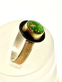 "This Gem Carico Lake Faustite Green Turquoise ring was fabricated in my studio using 18k gold, 14k gold, and sterling silver. This Carico Lake Turquoise Faustite cabochon is worthy to be set in gold.   The cabochon is set with a 1/8\" tall 18k Gold brushed finish bezel. It is soldered on a 24 gauge Sterling Silver antique textured plate. The sterling silver 12 gauge rectangle ring band is adorned with a wonderfully brushed finish 1/8\" wide 30 gauge strip of 14k Gold. The Ring is approximately 1/2\" long x 7/16\" wide and weighs 4.1 grams.  Due to the unique fabricated construction of this 14k Gold and Sterling Silver ring band I am unable to resize this ring. I have carefully measured the ring size as accurately as possible and posted it in this listing.  This ring is a size 7 3/4.  This Spiderweb Turquoise, Silversmith Jewellery, Sterling Silver Rings Bands, Cabochon Ring, Blue Gems, Green Turquoise, Jewelry Lover, Turquoise Jewelry, Custom Rings