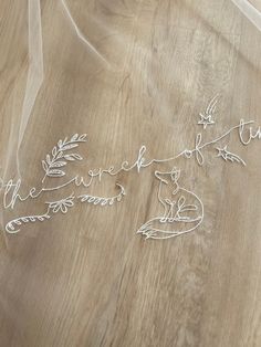 the bride and groom's initials are made out of wire on a wooden table