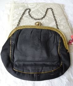 GORGEOUS antique French evening purse/bag. This French made handbag has an exceptionally beautiful brass frame, made with attention to detail and striking pattern. Finely detailed, beautiful design in black silk with aged gold thread decor. The silk has a couple of splits on one side, but detracting. The interior still has it's pink silk lame lining and has the original mirror still attached by the original gold thread. The closing is a 'kiss' closing that is working,just wonderful. It measures Vintage Gold Shoulder Bag For Formal Occasions, Vintage Gold Shoulder Bag, Vintage Evening Shoulder Bag, Handmade Victorian Evening Bag, Vintage Evening Bag For Vintage Events, Handmade Victorian Gold Bags, Victorian Handmade Evening Bag For Formal Occasions, Vintage Evening Bags With Brass Hardware, Antique Style Clutch For Vintage Events