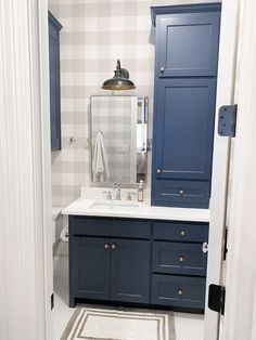 a bathroom with blue cabinets and white counter tops