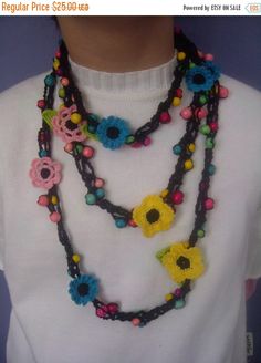 a woman wearing a multi - stranded necklace with flowers and beads on the front