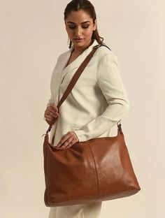 Our expertly crafted pure leather bags epitomize timeless elegance and enduring charm. Each bag is a unique masterpiece, showcasing natural leather variations, and adding character to your style. Ideal for office, getaways, or everyday use Brown textured solid shoulder bag 1 main compartment, has a zip closure, 1 inner pockets One handle with a detachable sling strap Bag Dimensions : - Bag: 13.75" H x 20.5" W x 5.75" D Strap(s): 28.5" min L - x 53" max L x 1.2" W Drop length: 13" min L - x 27" m Elegant Shoulder Bag With Adjustable Strap For Travel, Elegant Travel Bag With Double Handle For Daily Use, Luxury Hobo Bag With Leather Handles For Travel, Elegant Everyday Shoulder Travel Bag, Elegant Tote Travel Bag For Daily Use, Elegant Travel Bag With Removable Pouch For Everyday Use, Elegant Daily Use Tote Travel Bag, Elegant Crossbody Travel Bag With Adjustable Strap, Elegant Everyday Travel Bag With Double Handle