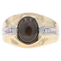 a gold ring with a black stone and diamonds