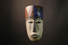 a wooden mask with two different colored faces