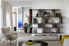 a living room filled with furniture and bookshelves next to a dining room table