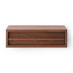 an empty wooden shelf on a white wall