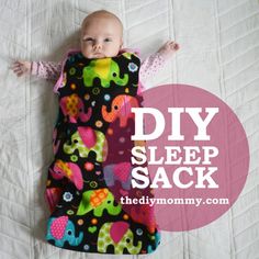 a baby laying on top of a bed wearing a sleeping bag with an elephant print