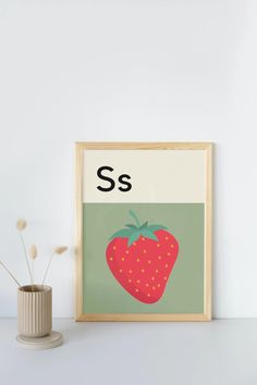 a strawberry with the letter s on it is next to a plant in a vase