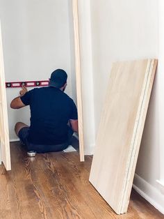 a man sitting on the floor in front of two pieces of plywood planks