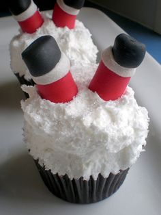 two cupcakes with red and white toppers on them sitting on a plate